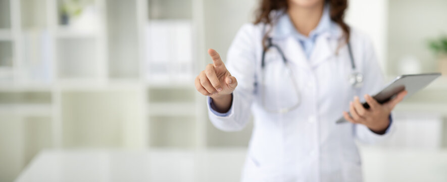 Cropped of woman doctor with digital tablet touching screen