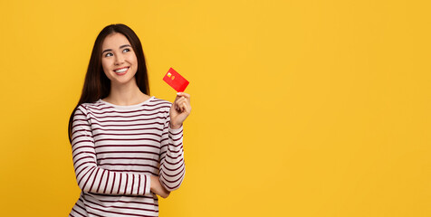 Positive young asian lady showing bank credit card
