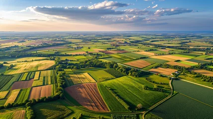 Foto op Canvas Aerial view of a sprawling agricultural landscape with patchwork fields and winding country roads. © Peter