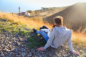Romantic couple dressed in cozy sweaters together near the lighthouse