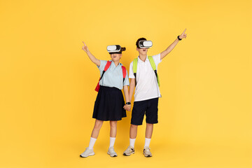 Two schoolchildren with backpacks are engaged in a virtual reality experience, pointing upwards