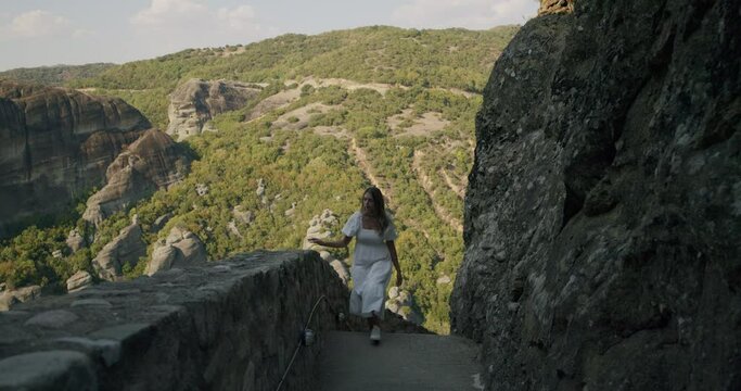 A young woman in a floaty long dress. Meteora, Greece.