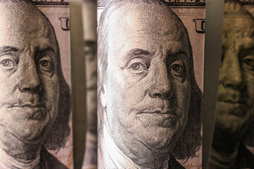 A fragment of a hundred dollar bill with a portrait of Franklin. Finance and economics concept. Selective focus.