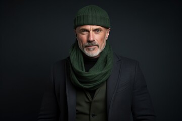Portrait of a senior man in a green knitted hat and coat.