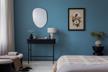 Minimalistic composition of cozy bedroom interior with mock up poster frame, bed, gray bedding, stylish bedside table, vase with flowers, blue wall and personal accessories. Home decor. Template.	
