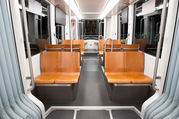 Empty public transportation tram car. Inside shot, nighttime, no people, empty seats