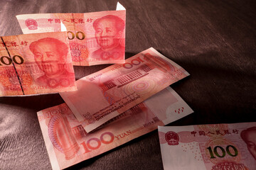 Chinese yuan in counter light against a dark background. Concept of finance and economics....