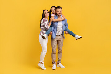 Happy European Family Of Three Having Fun Together Over Yellow Background