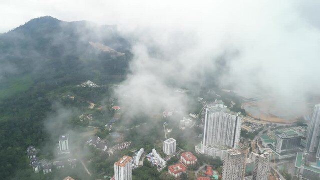 An aerial shot of the Genting Highlands area of Malaysia. The video moves through the misty cloud revealing the highlands beauty.