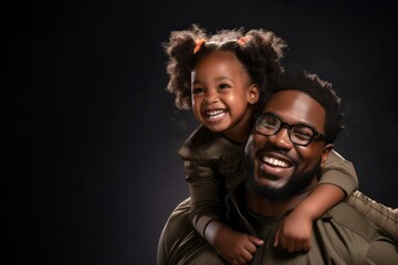 Afro father carrying cute little girl piggyback, both smiling.
