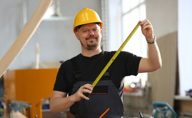 Handsome worker measuring. Manual job DIY inspiration improvement job fix shop yellow helmet joinery startu workplace idea designer career ruler industrial education