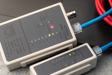 Checking the integrity of computer wires with a network cable tester, close-up of a LAN tester