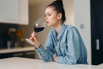 Lonely, Desperate Woman Sipping Red Wine in Fashionable Dress, Surrounded by Elegance and Sadness