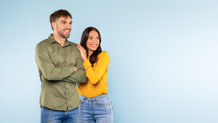 Confident man with arms crossed and cheerful woman on blue background, copy space