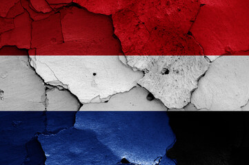 flags of Netherlands and Yemen painted on cracked wall
