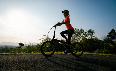 Fototapeta na wymiar Riding folding bike on sunny mountain top road