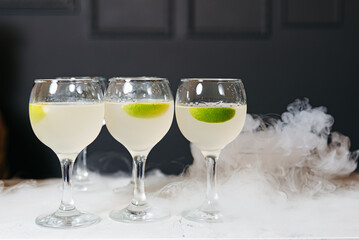 Chilled Cocktails in Misty Nitrogen Clouds. Elegant stemware filled with chilled cocktails enveloped by dramatic nitrogen clouds, creating a captivating display.