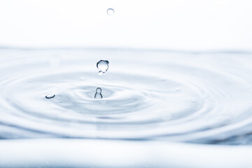 Captivating water droplet creates intriguing shapes, generating motion and splashes against a...