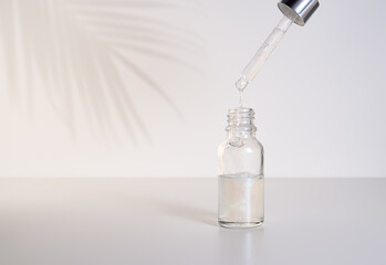 Glass bottles with open dropper pipettes. Luminous and luxury silver and white liquid highlighter drops