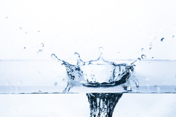 Vibrant splash of water with bubbles as fruit drops into pristine water on a white background. Ideal for banners promoting freshness and purity.