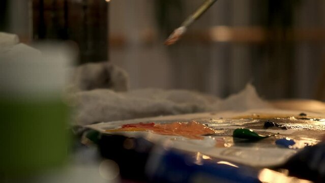 Closeup woman female hand artist painter paints draws creating new art work on canvas in workshop lesson of painting enjoying process of drawing creating picture using brush applying oil paint palette