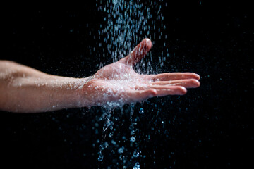 Fototapeta na wymiar Closeup shot of a human's hand with water flowing onto it
