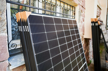 Stack of new solar panels with protective cardboard, ready for installation. Renewable energy, sustainable home improvements, and eco-friendly investments in residential property infrastructure.