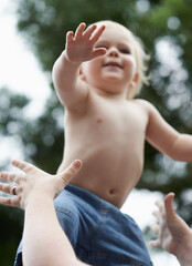 Baby, mother and playing outdoor for development with nurture, relationship and bonding for happiness. Family, child or toddler and hands with early childhood, parenting and love at park in nature