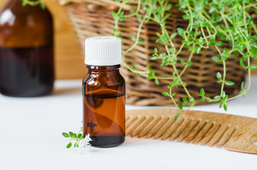 Small bottle with essential thyme oil. Aromatherapy, natural health care and herbal medicine concept.