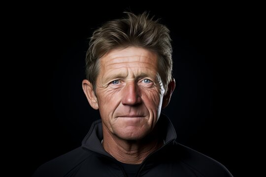 Portrait of a senior man looking at camera over black background.