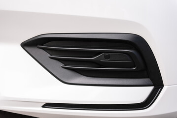 Front right parktronic on a modern white new car. Detail metallic bumper car. Exterior automobile closeup.