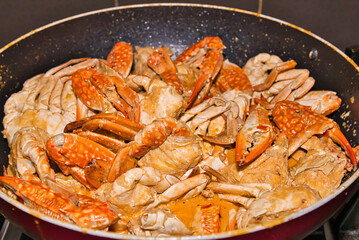 Festive dinner, garlic butter crabs in cooking pan 