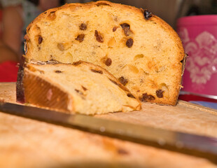 Panettone on chopping board, one cut slice and a cake knife during festive seasons