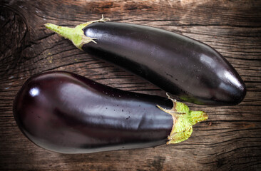 Fresh eggplants with leaves over dark background