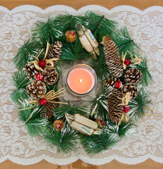 Christmas and new year season, candle between fir sprig, candle, cones and red mushroom heads
