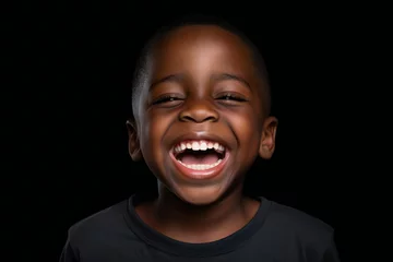 Foto op Canvas a professional portrait studio photo of a cute african boy child model with perfect clean teeth laughing and smiling. isolated on black background. for ads and web design © JAYDESIGNZ
