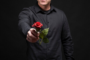 Hombre entregando una flor rosa roja