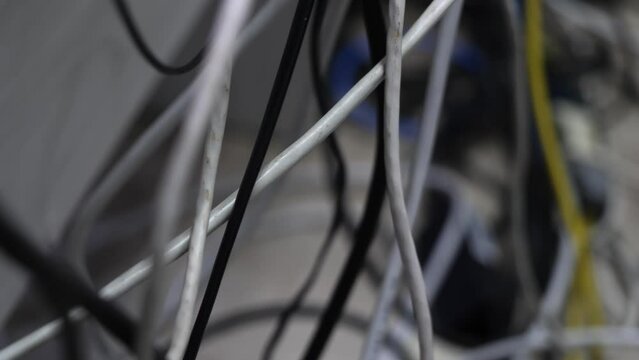 many wires are haphazardly connected to the outlet, to the router and to other devices. Clutter in the workplace. Electrical cables, internet cables and various wires were laid out at random.