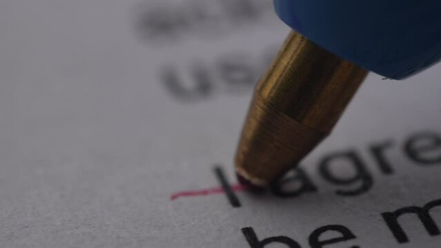Pen Crossing Out 'I Agree' on Document. Extremely Close-up, shallow dof.