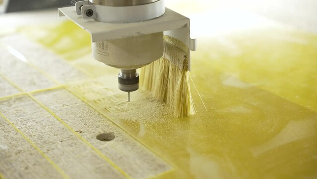 Milling cutter cuts plastic part on robotized production line. Factory robots