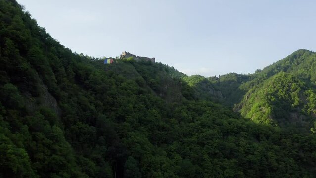 Poenari fortress in Romania. Aerial 4k video with this amazing fortress on top of a peak hill from Fagaras Mountains, the place where Vlad Dracula lived. Travel to Romania landmarks. Sunset sky.