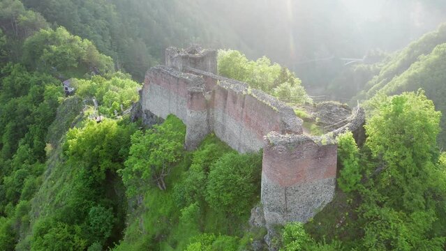 Poenari fortress in Romania. Aerial 4k video with this amazing fortress on top of a peak hill from Fagaras Mountains, the place where Vlad Dracula lived. Travel to Romania landmarks. Sunset sky.