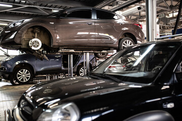 Tyres car service. Man working at a car to repair its parts at an auto vehicles service. Concept image for tyre cars maintenance.
