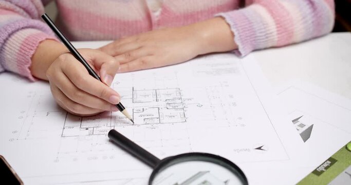Closer shot of an individual finalizing the sketches of an architectural draft for a floor plan of a new house.