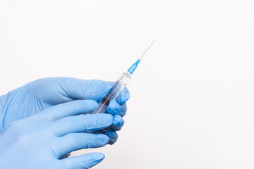 The hands of a doctor or nurse in blue medical gloves hold a syringe filled with medicine. Banner...