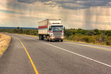 truck on the road, african landscape after a storm in a rainy day - obrazy, fototapety, plakaty