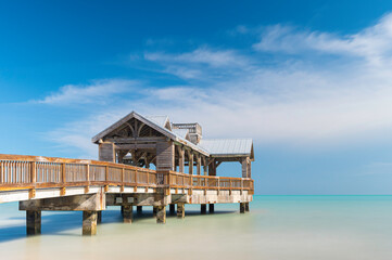 Wooden pier, located in Key West, Florida, reaching out into the calm tropical waters of the turquiose ocean, on a sunny, summers day