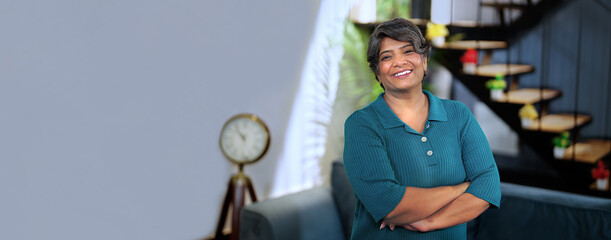 Happy Indian middle aged smile businesswoman look at camera pose for video Independent grey haired...