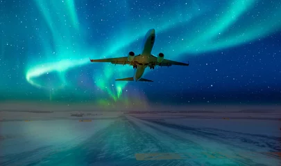 Fotobehang Commercical white airplane fly up over take-off runway the (ice) snow-covered airport with aurora borealis - Norway © muratart
