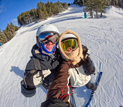 Selfie of a couple skiing in the mountains.